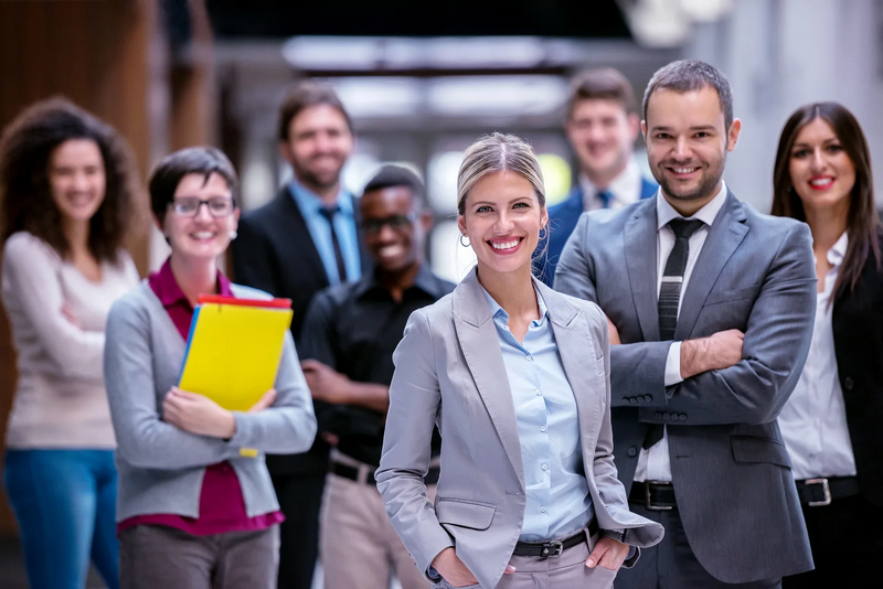 A group of professionals in business attire standing together and smiling.